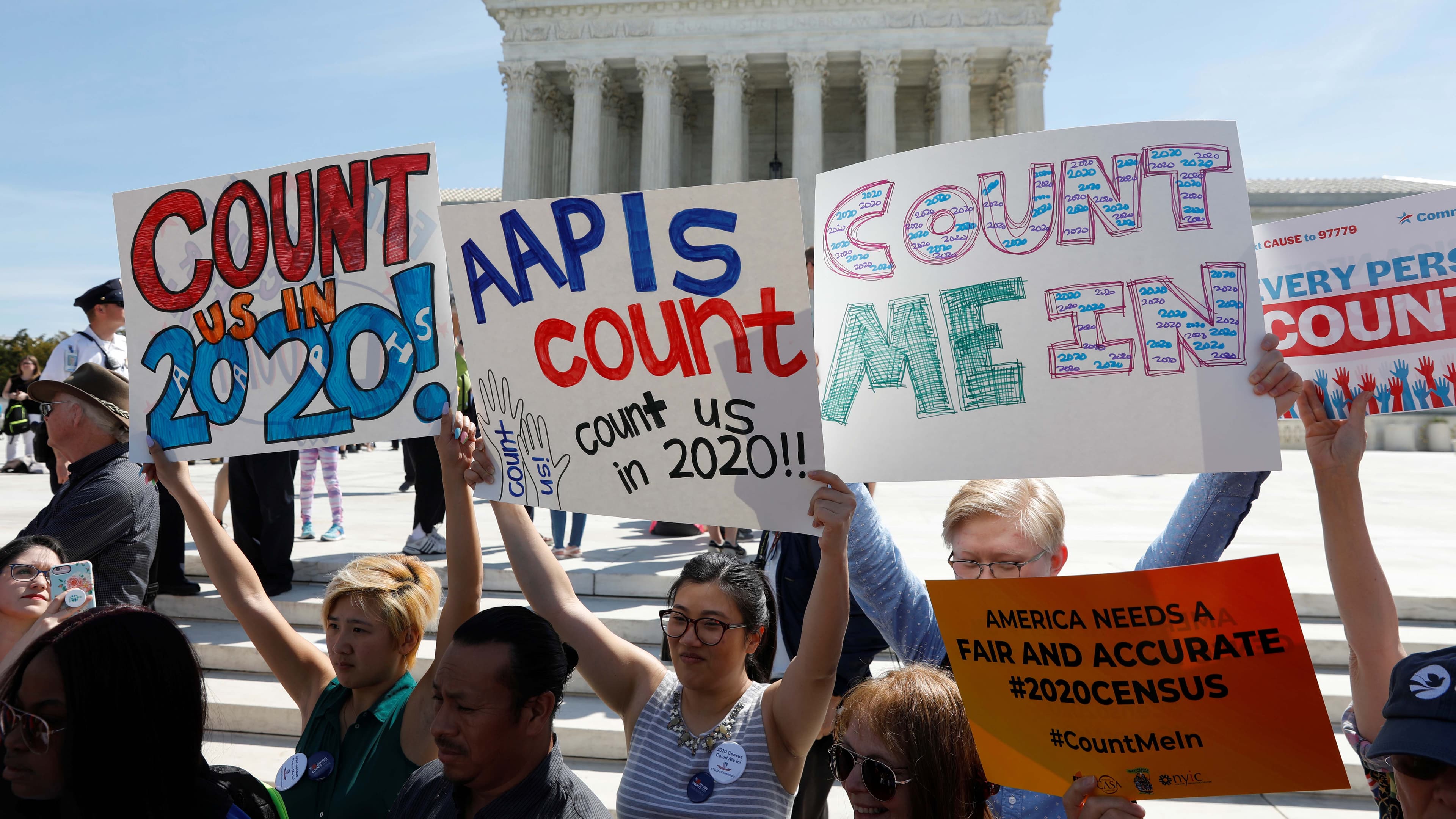 Demonstrators hold signs