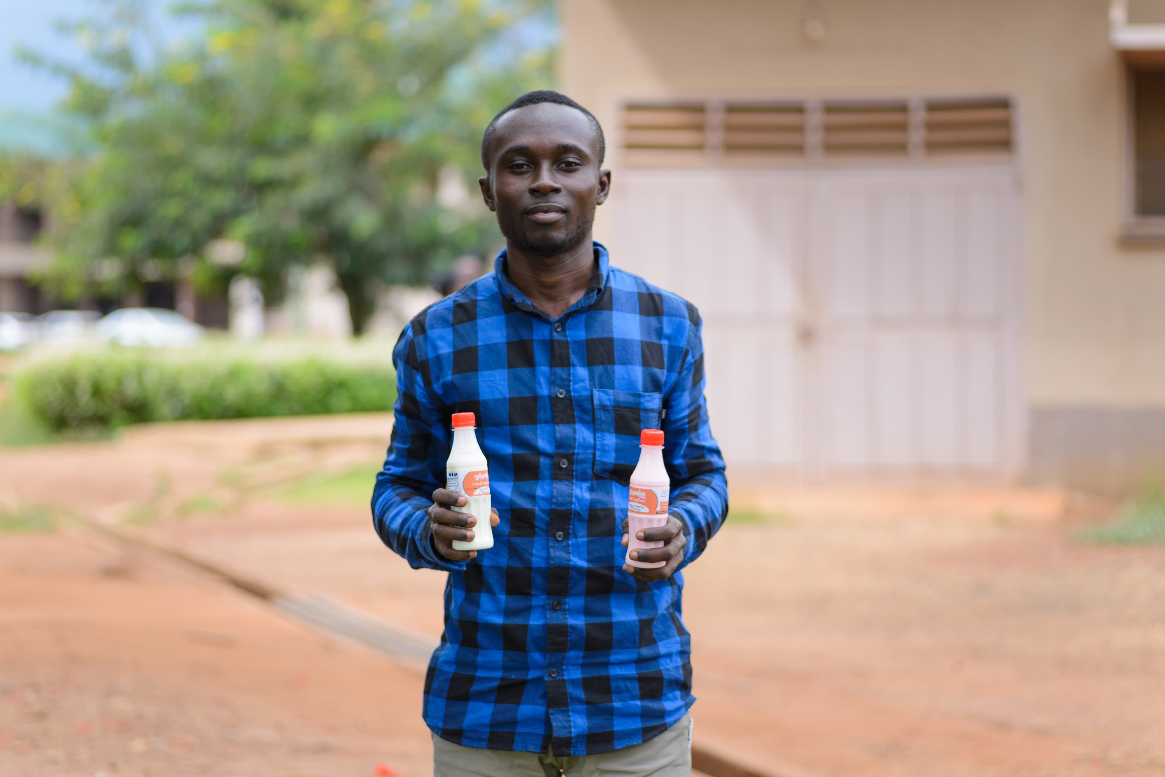 A young man holds his yogurt products