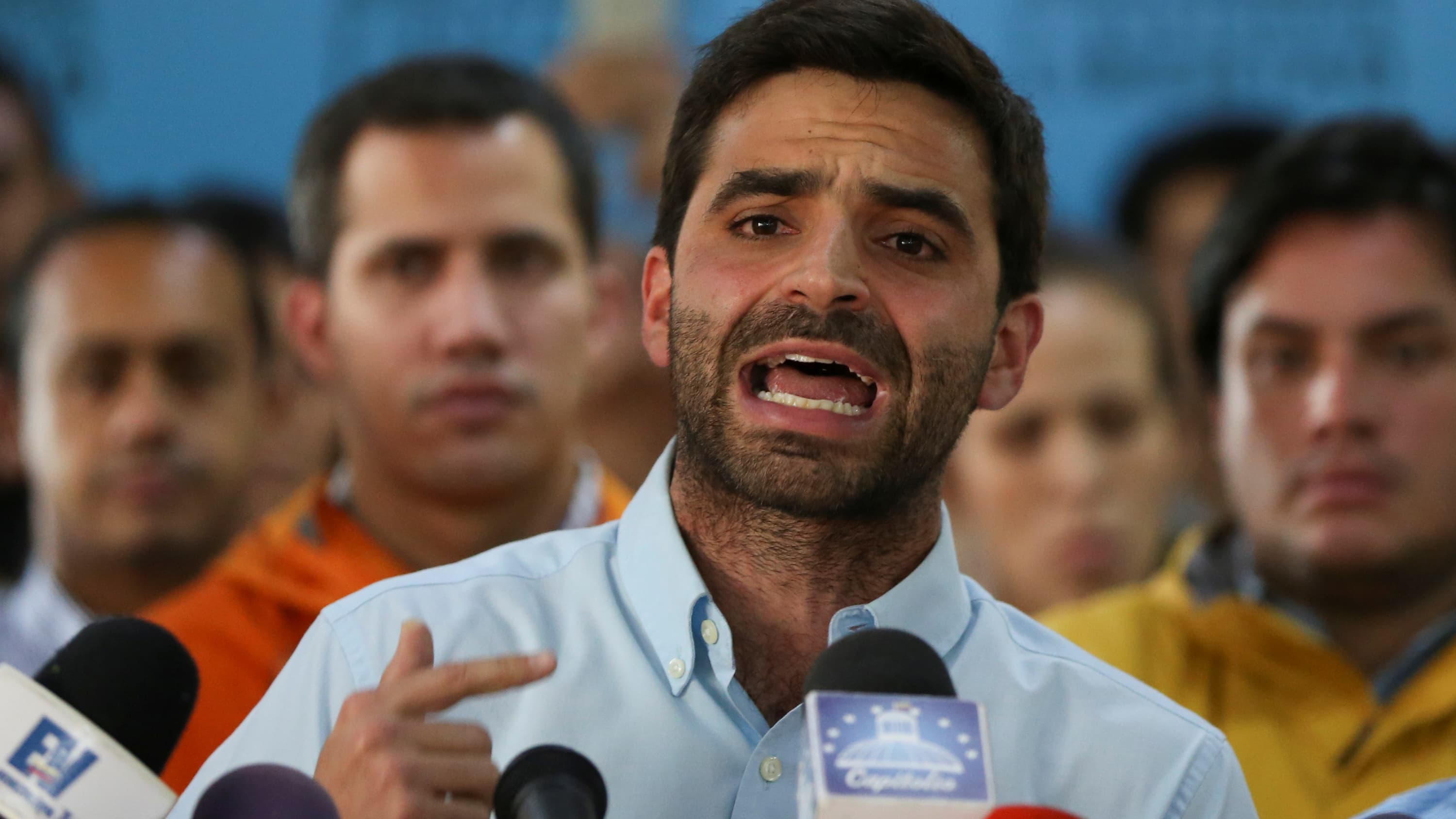 A man speaks into microphones