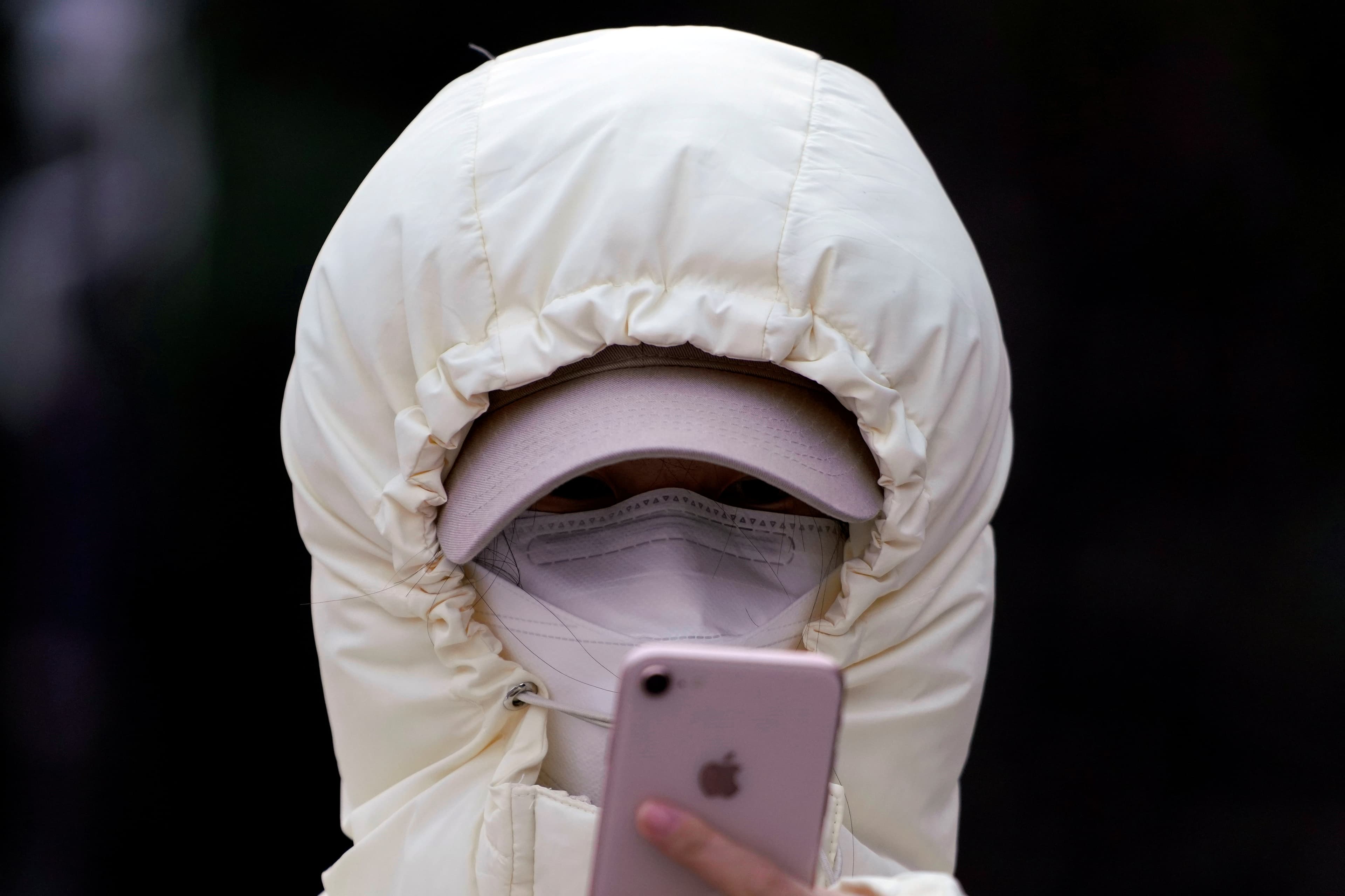 A woman wearing a mask checks her mobile phone in Shanghai, Jan. 29, 2020.