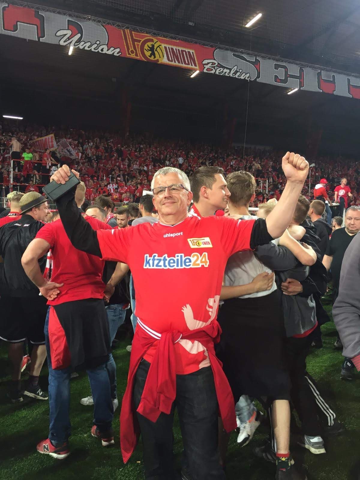 Uwe Dahkle wears a red jersey at a soccer game.