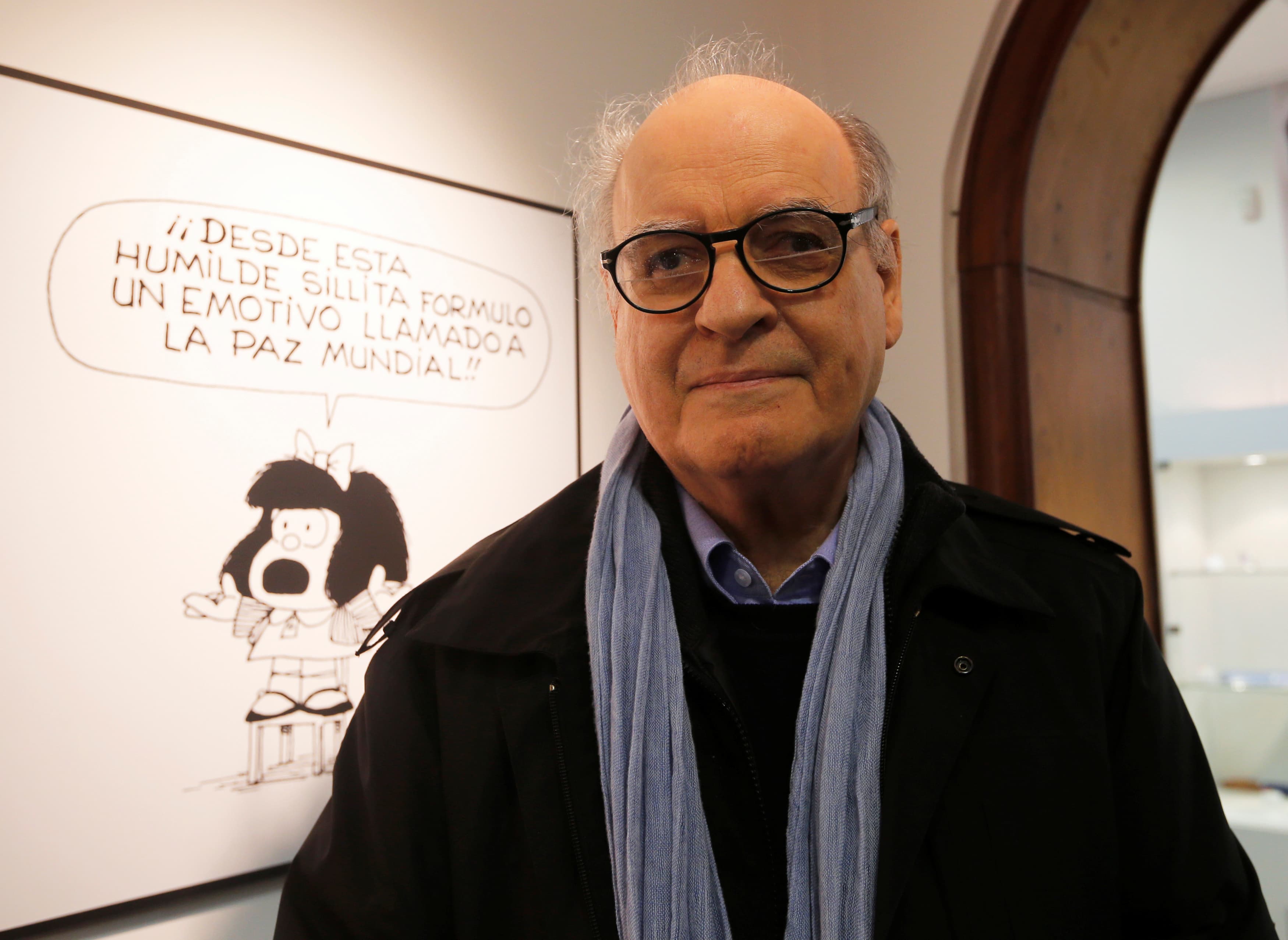 Argentine cartoonist Joaquín Salvador Lavado, also known by his pen name Quino, poses in front of an image of his most famous comic character Mafalda during the opening ceremony of the exhibition of his works at the Museo del Humor in Buenos Aires, June 1