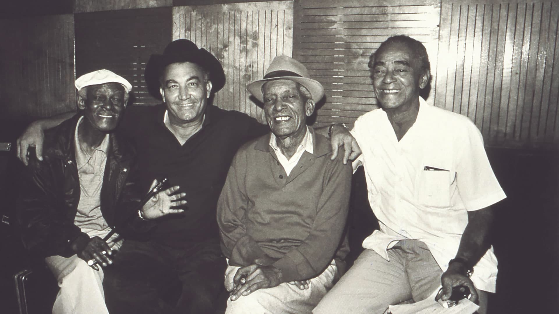 A black and white photo of Buena Vista Social Club members Ibrahim Ferrer, Eliades Ochoa, Comapy Segundo and Puntillita Licea.