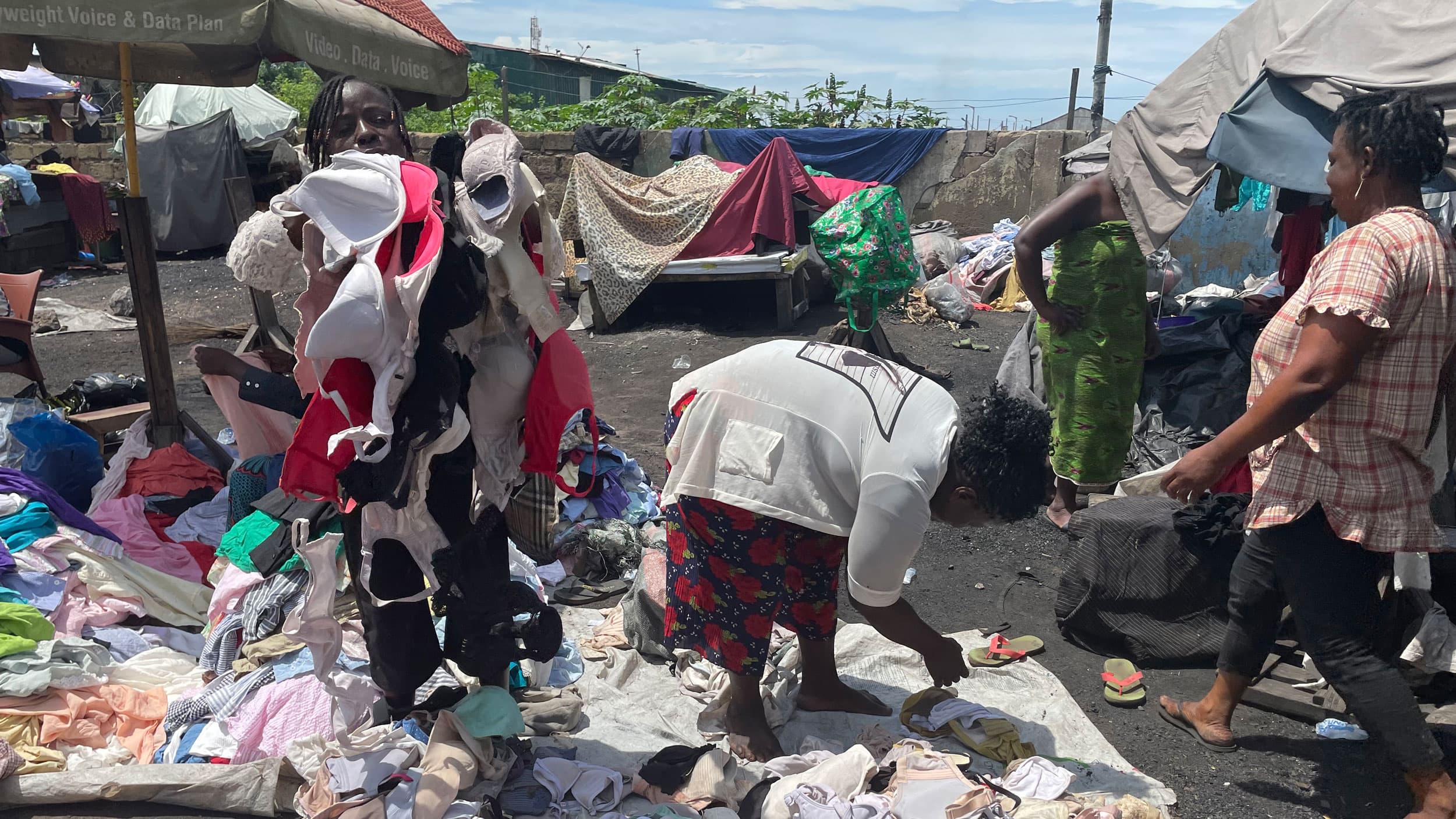 Seller Edith Affrem holds dozens of used bras as she touts her goods for customers.