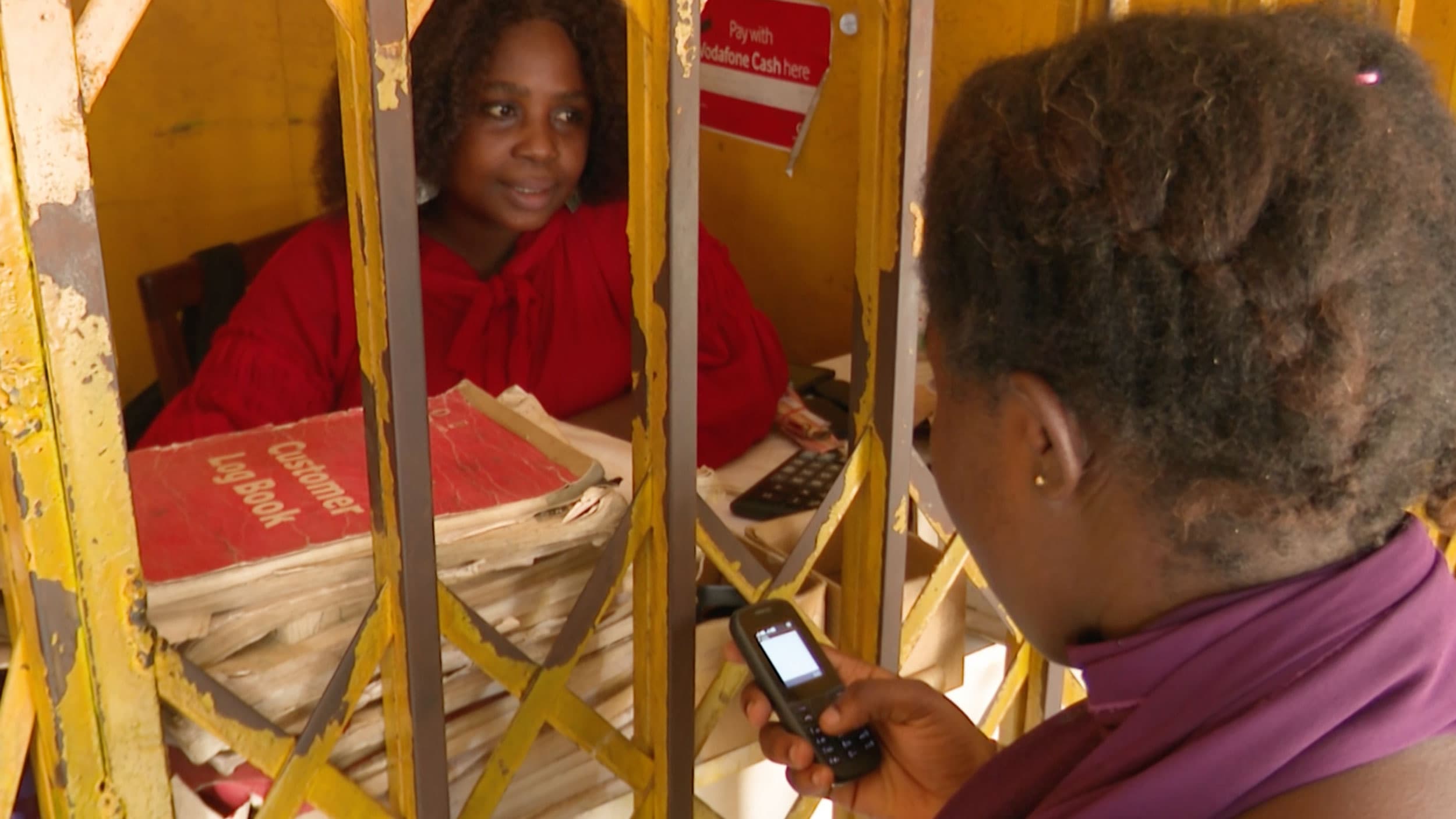 Salormey Ayertey attends to a customer at her telecommunications shop in suburban Accra, Ghana.