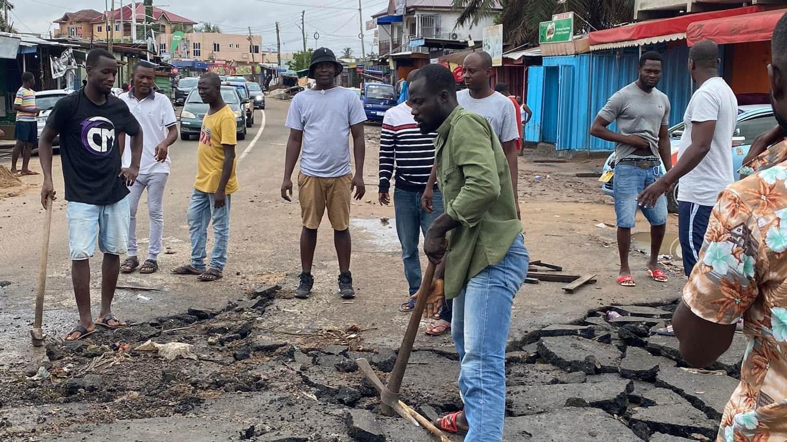 Residents of the Accra suburb of Alajo patch up a road after severe flooding destroyed it.