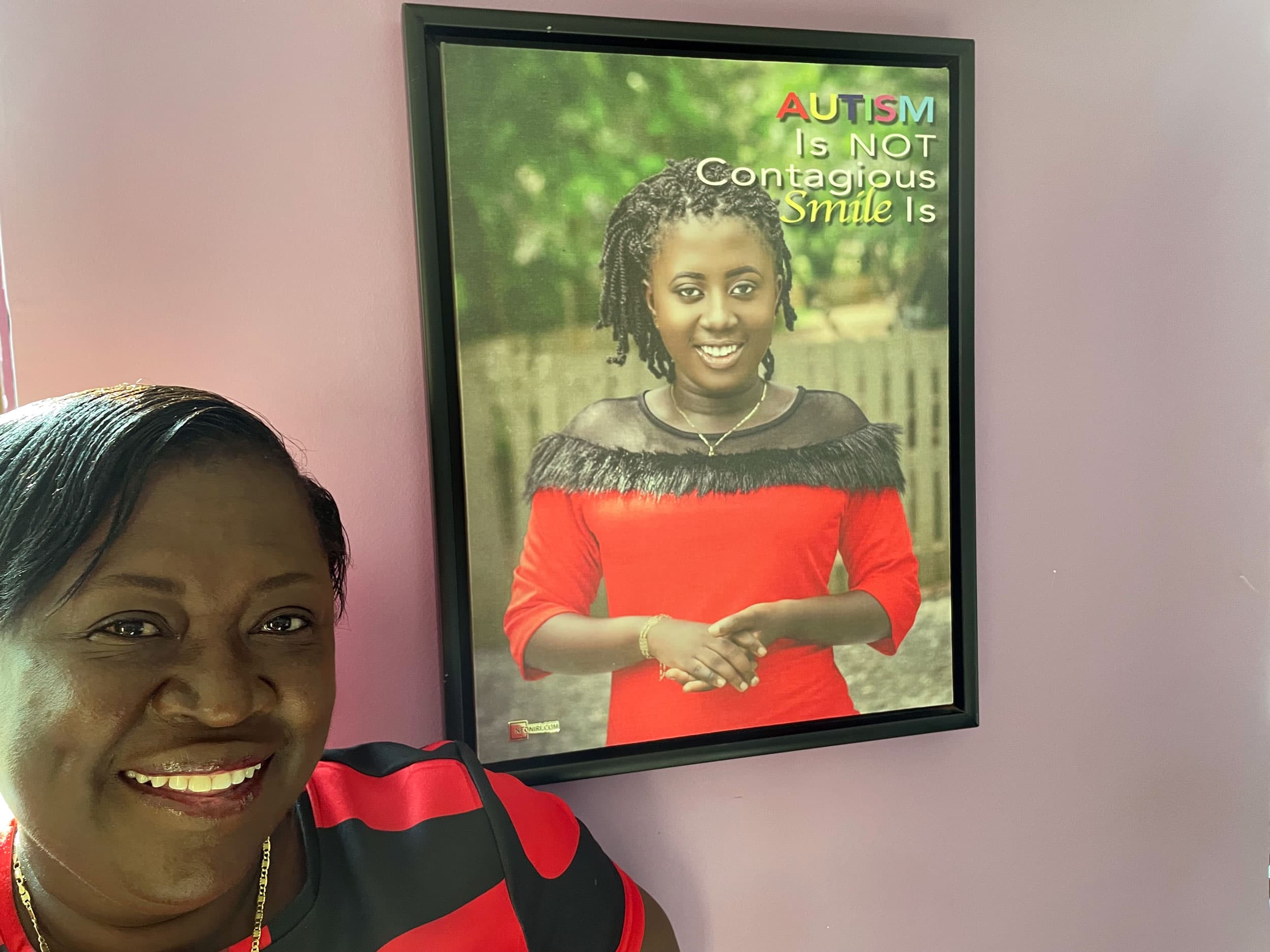 Mary Kufuor, founder of Klicks Africa Foundation, stands by a portrait of her autistic daughter, Nana Yaa.