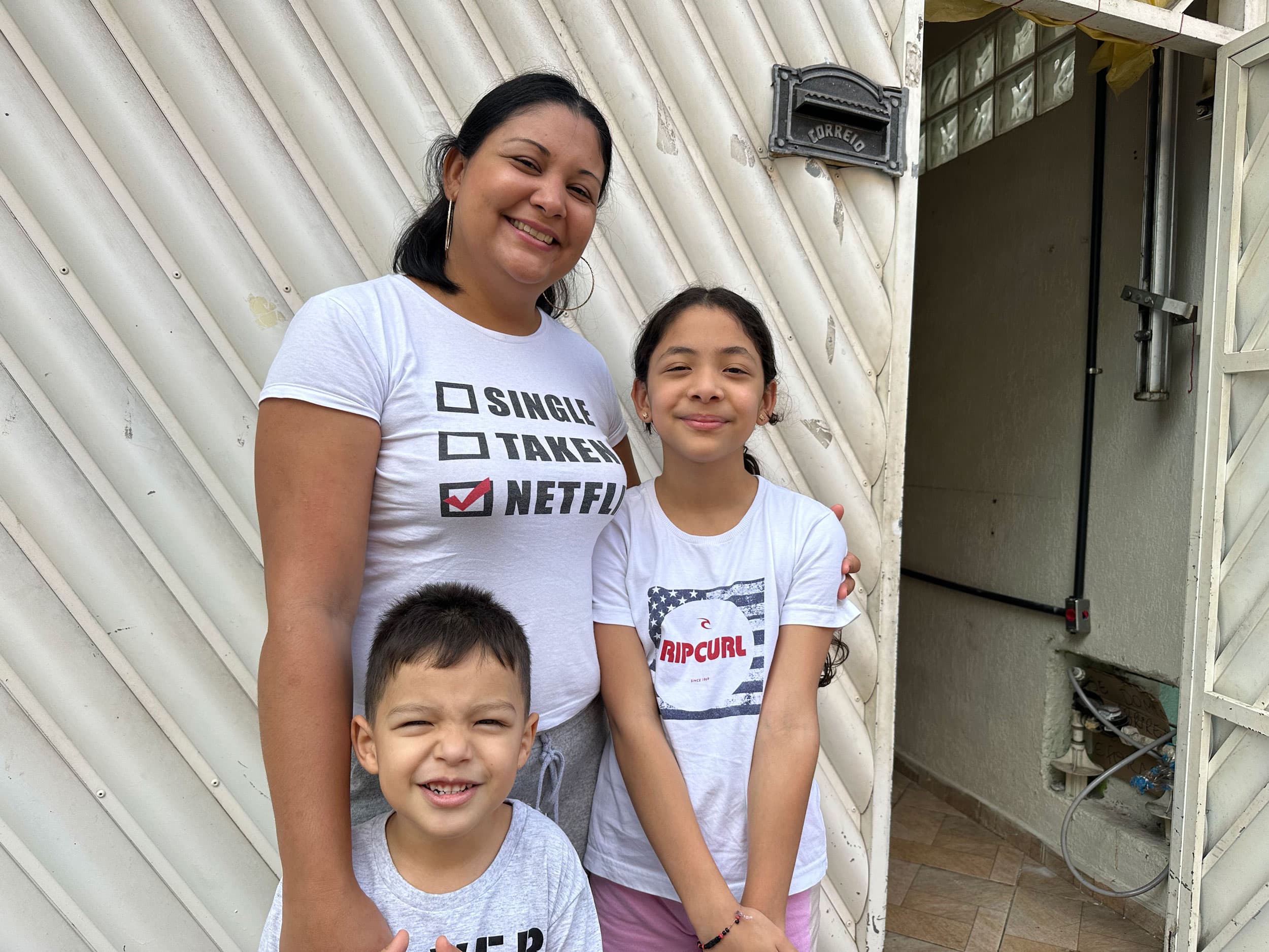 Yoselin Calcurian with her youngest son Josué, 4, and daughter Sofia, 9, in front of their one-bedroom apartment in Vila Natal that they converted into a two-bedroom.