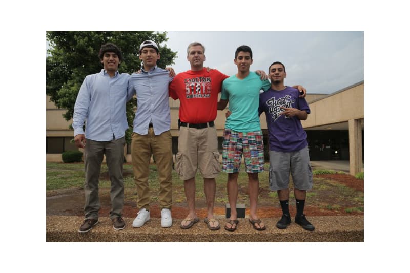 Coach Matt Cheaves stands with members of the Dalton High School soccer team in Dalton, Ga.