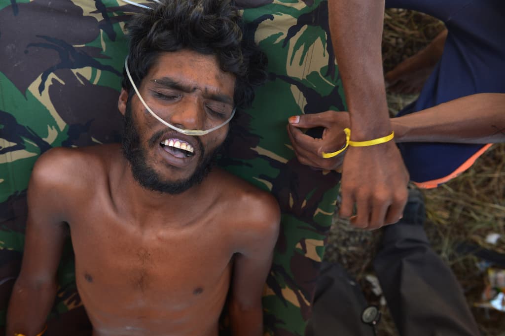 Indonesian medical workers attend to a Bangladeshi migrant rescued from a boat and taken to the Indonesian town of Langsa in Aceh province.